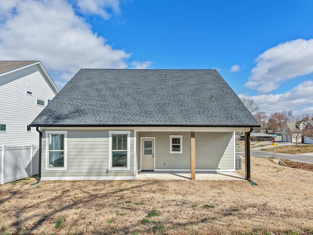 back of house featuring fence, a patio, and roof with shingles