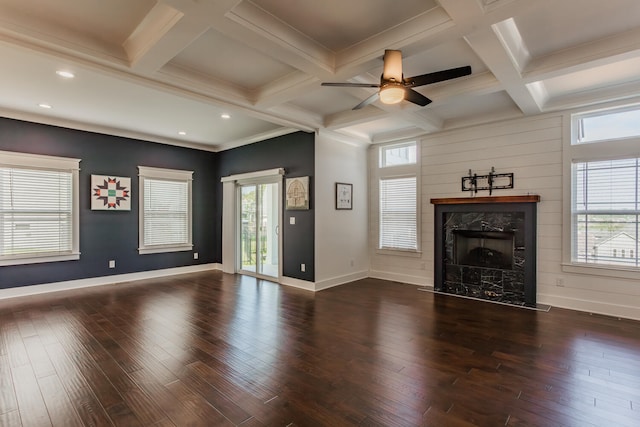 unfurnished living room featuring a wealth of natural light, dark wood-type flooring, ceiling fan, and a fireplace