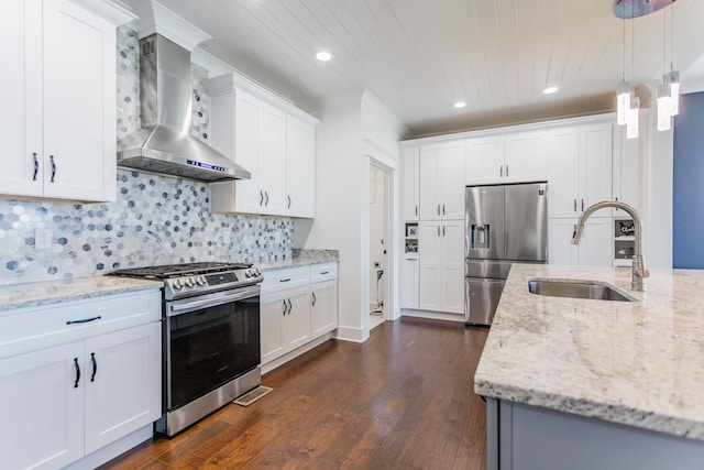 kitchen featuring dark hardwood / wood-style flooring, appliances with stainless steel finishes, sink, white cabinetry, and wall chimney range hood