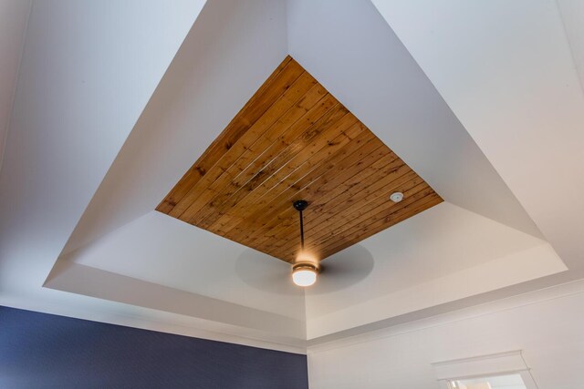 interior details featuring ceiling fan, wooden ceiling, and a tray ceiling