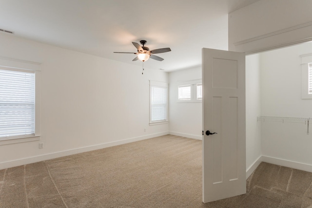 carpeted spare room with ceiling fan