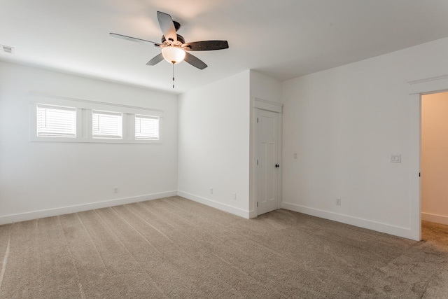 carpeted spare room featuring ceiling fan