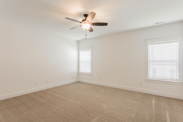 carpeted spare room featuring ceiling fan