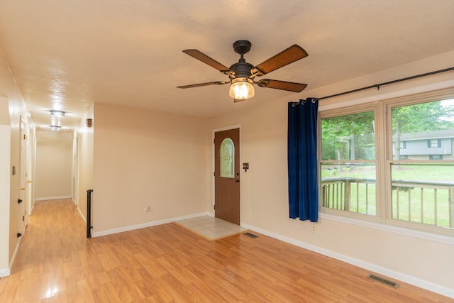 spare room with ceiling fan and light wood-type flooring