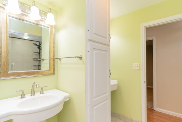 bathroom featuring sink, hardwood / wood-style floors, and a tile shower