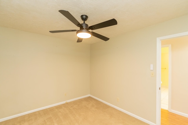 unfurnished room featuring a textured ceiling, ceiling fan, and light carpet