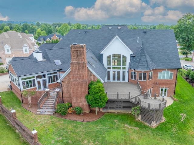 rear view of house featuring a deck and a lawn