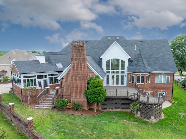 rear view of property with a deck and a lawn