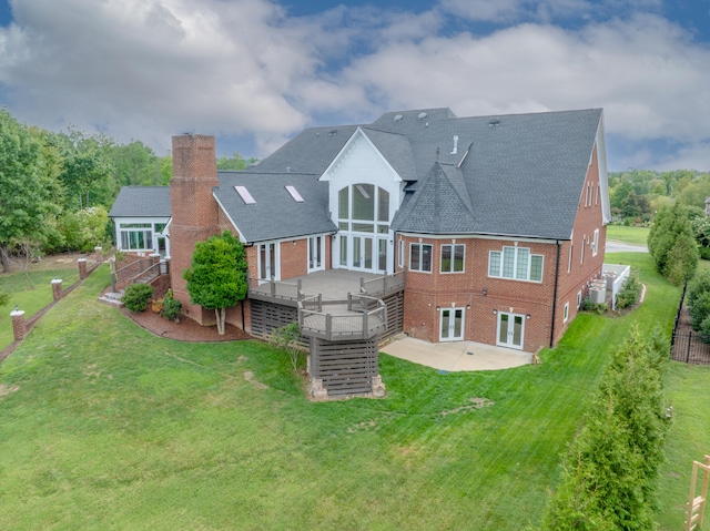 rear view of house featuring a lawn, a patio, and a deck