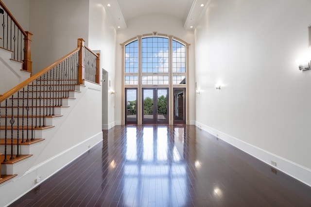 foyer entrance featuring dark wood-type flooring and a high ceiling