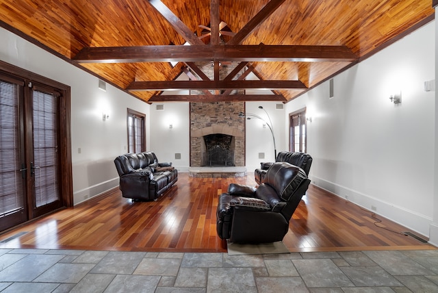 living room with vaulted ceiling with beams, a stone fireplace, wooden ceiling, and hardwood / wood-style flooring