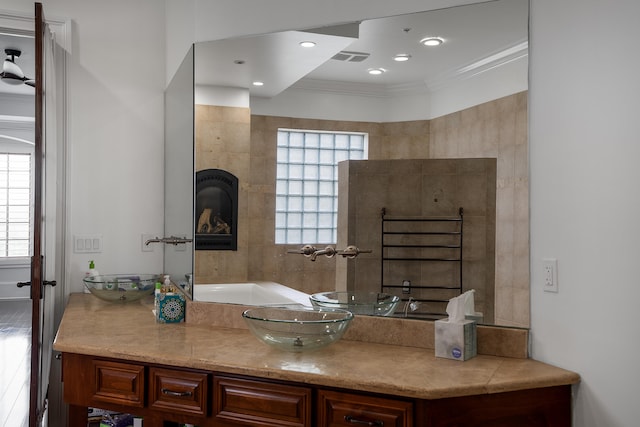 bathroom with ornamental molding, vanity, and wood-type flooring