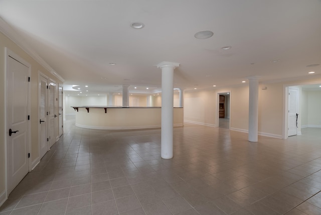 basement with crown molding and light tile patterned floors