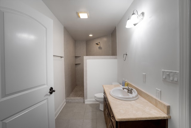 bathroom with tile patterned floors, toilet, a tile shower, and vanity