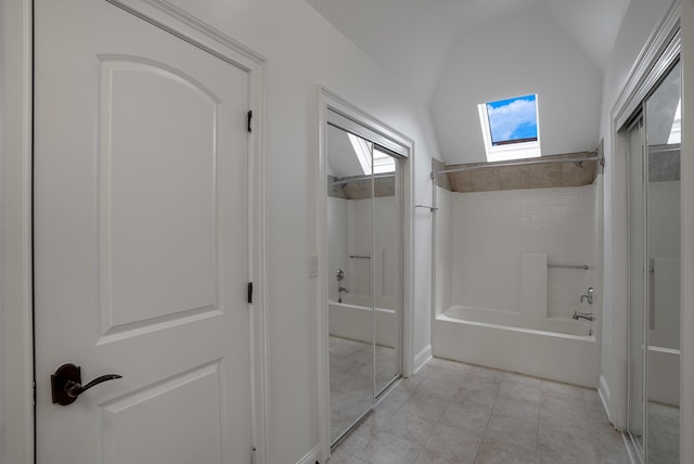 bathroom with tiled shower / bath and lofted ceiling with skylight