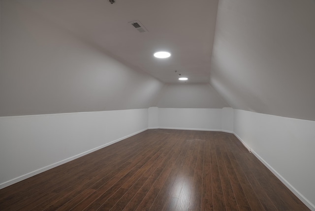 additional living space featuring dark wood-type flooring and lofted ceiling