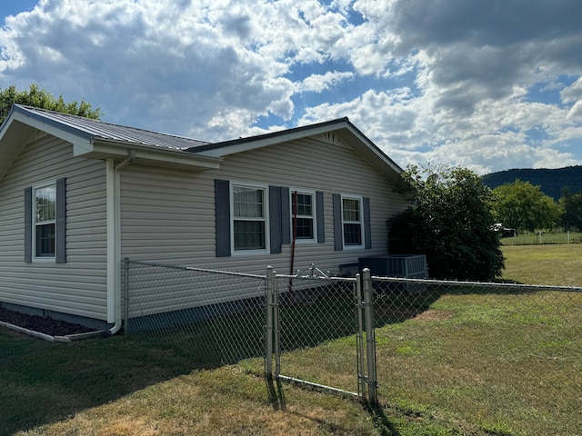 view of property exterior with a yard and cooling unit