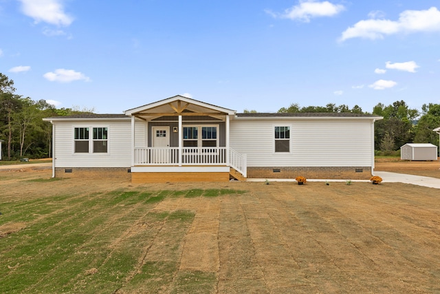 manufactured / mobile home with a storage shed and covered porch