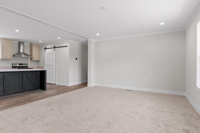 interior space featuring a barn door, ornamental molding, and light wood-type flooring