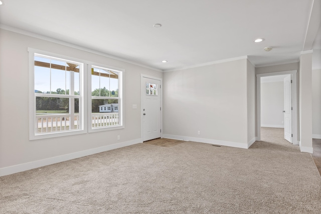 carpeted spare room featuring crown molding