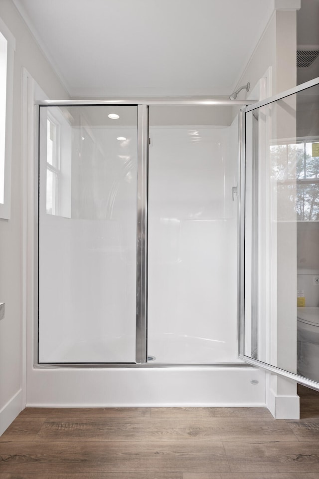 bathroom featuring hardwood / wood-style flooring and walk in shower