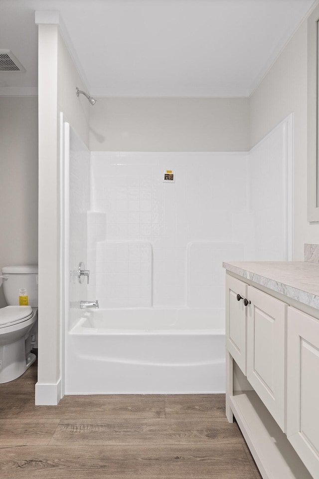 full bathroom featuring vanity, shower / bath combination, hardwood / wood-style floors, and toilet