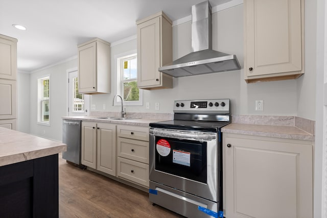 kitchen featuring wall chimney range hood, crown molding, dark wood-type flooring, sink, and appliances with stainless steel finishes