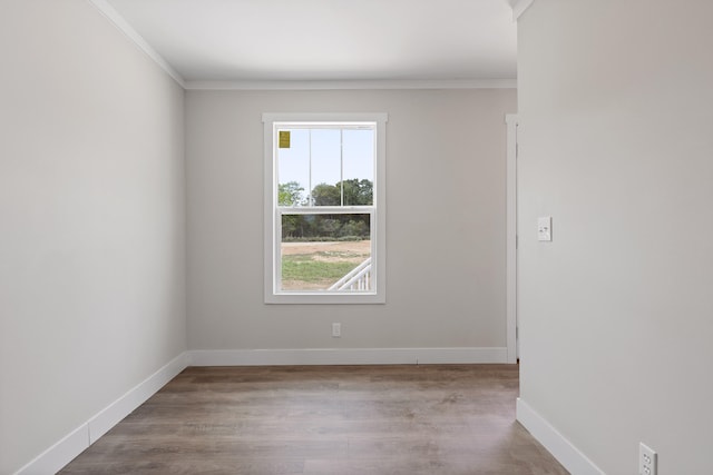 spare room featuring ornamental molding and light wood-type flooring