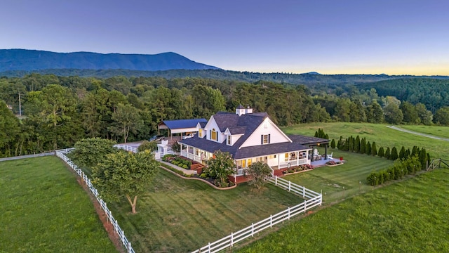 aerial view at dusk with a mountain view and a rural view