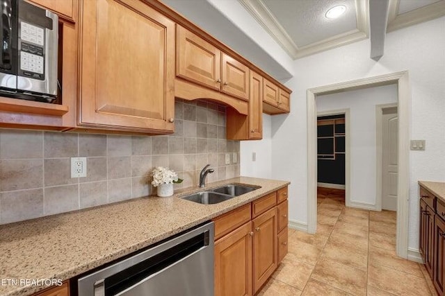 kitchen featuring ornamental molding, stainless steel appliances, light stone counters, sink, and light tile patterned flooring