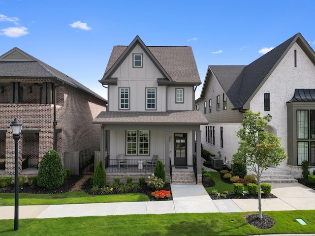 view of front of home featuring a front yard, covered porch, and central air condition unit