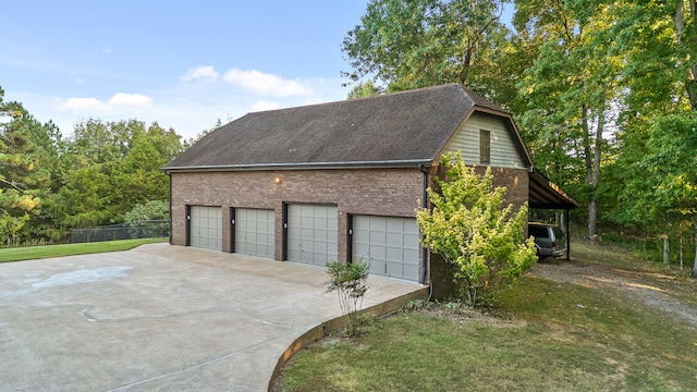 garage with a carport and a yard