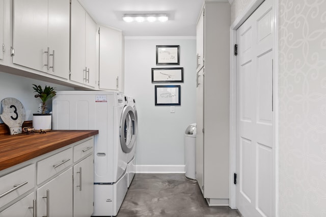 washroom featuring cabinets, ornamental molding, and washing machine and dryer