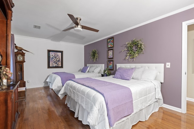 bedroom with ceiling fan, dark hardwood / wood-style floors, and crown molding