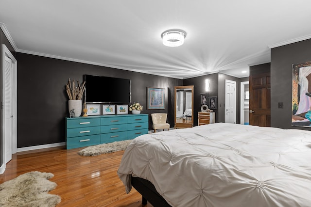 bedroom with ornamental molding and hardwood / wood-style floors