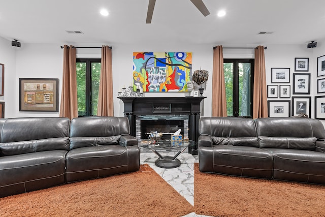 carpeted living room with ceiling fan and a healthy amount of sunlight