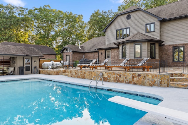 view of pool with a patio, a diving board, and grilling area