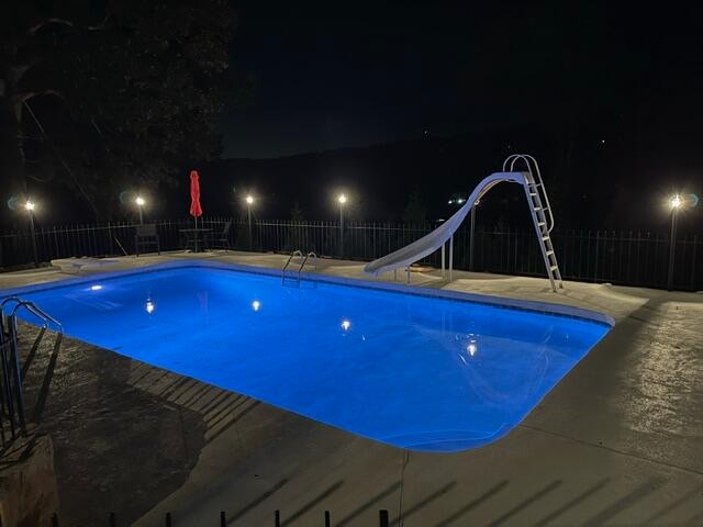 pool at twilight featuring a water slide