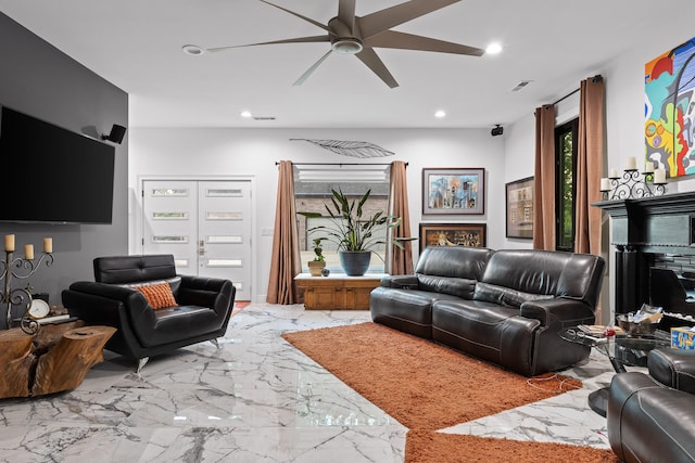 living room featuring a fireplace and ceiling fan