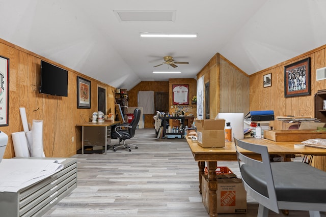 office space featuring ceiling fan, lofted ceiling, wood walls, and light hardwood / wood-style floors