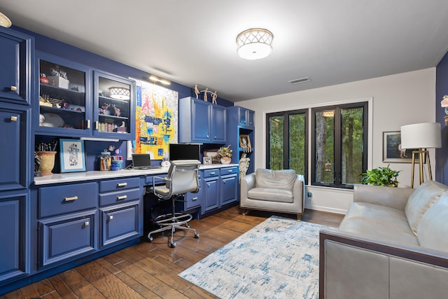 office space featuring built in desk and dark hardwood / wood-style flooring