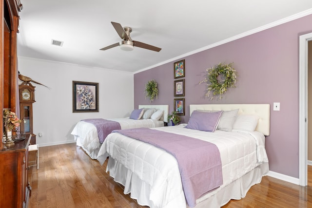 bedroom featuring ornamental molding, light hardwood / wood-style floors, and ceiling fan