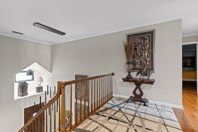 corridor featuring wood-type flooring and ornamental molding