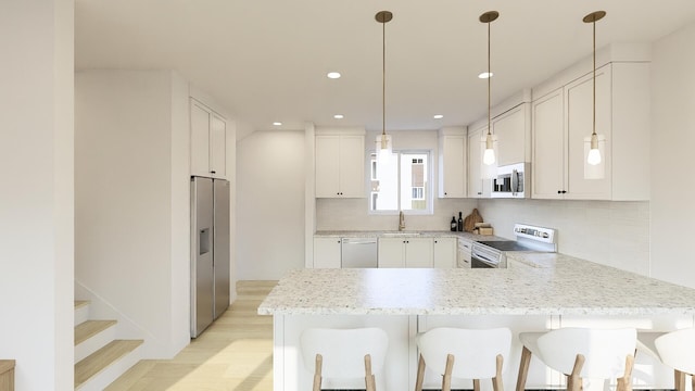 kitchen featuring appliances with stainless steel finishes, white cabinets, and light hardwood / wood-style floors