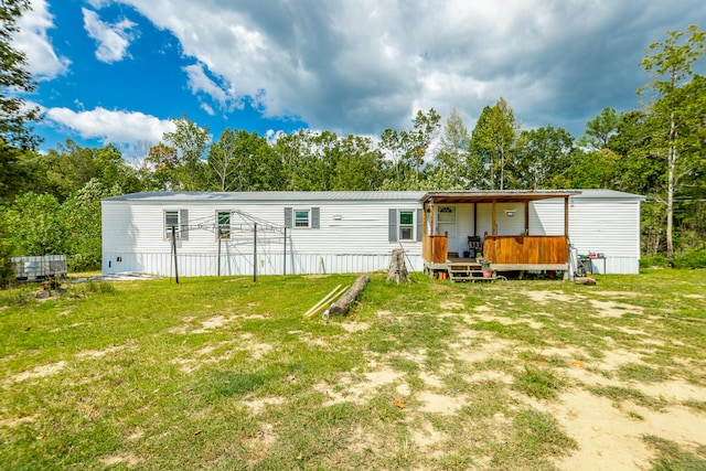 back of property with a lawn and a wooden deck