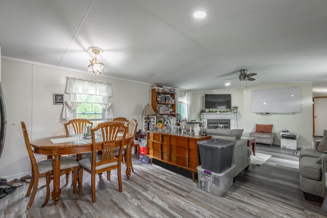 dining space with ceiling fan, ornamental molding, hardwood / wood-style floors, and vaulted ceiling