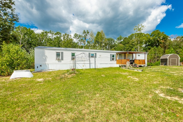 rear view of property featuring a yard and a storage shed