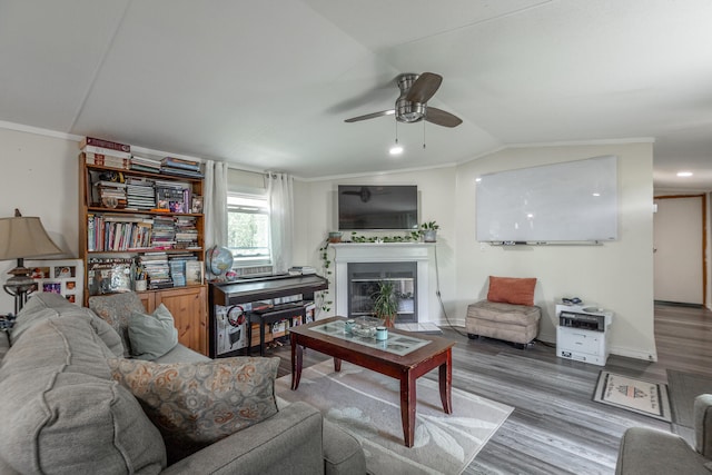 living room featuring crown molding, vaulted ceiling, hardwood / wood-style flooring, and ceiling fan