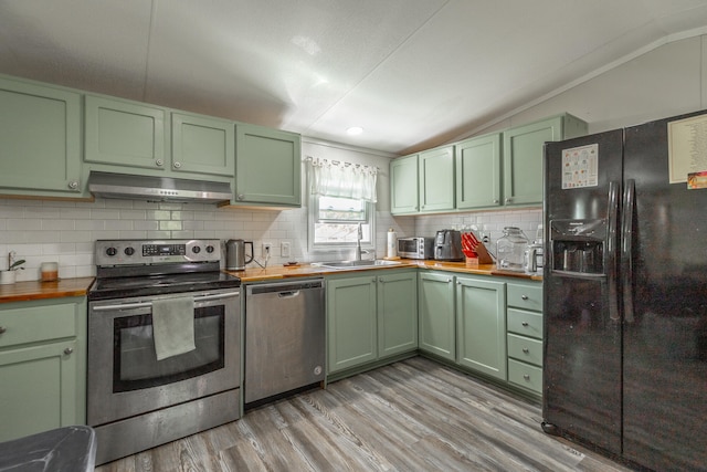 kitchen featuring light hardwood / wood-style flooring, wood counters, appliances with stainless steel finishes, sink, and green cabinetry