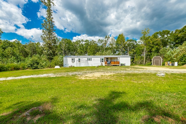 manufactured / mobile home with a storage shed and a front lawn